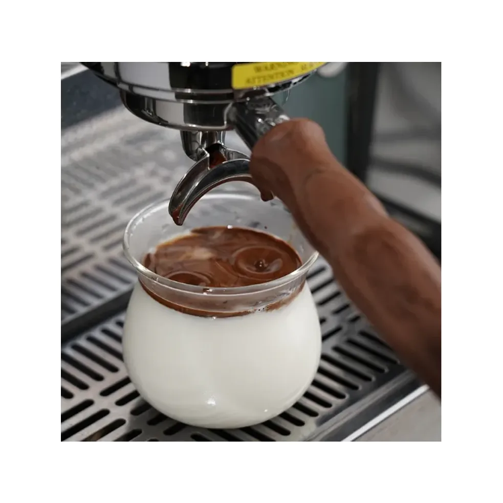 IKAPE Sense Kaffeeglas, 300 ml, mit Milch auf einer Abtropfschale, Espresso tropft aus einem Siebträger hinein